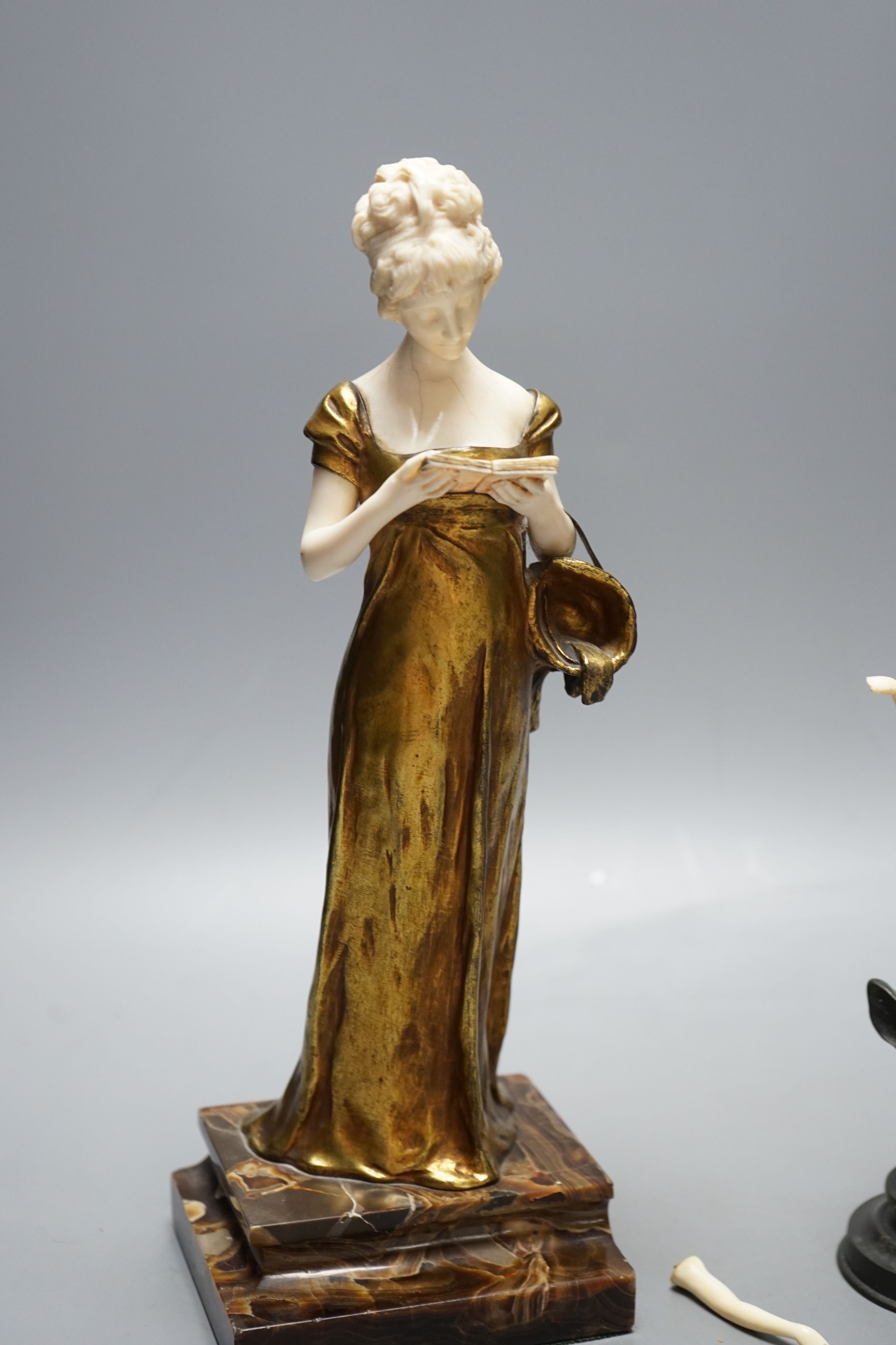 Georges Van Der Straeten, Belgian 1856-1928, An Art Deco bronze and ivory figure of a girl reading a book together with a smaller bronze and ivory figure, Tallest 31.5 cms high.